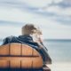 elderly man on the beach sitting in a wooden chair