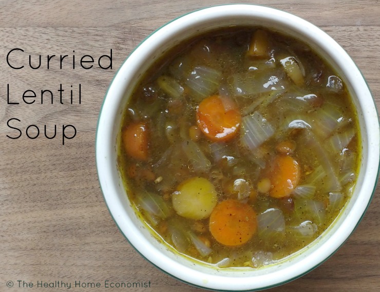 curry lentil soup in a white bowl on a cutting board