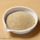 small white bowl of pearl millet on a cutting board