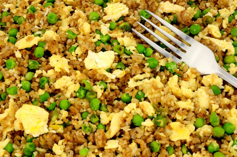 egg fried rice with peas on a plate with fork