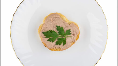 chicken liver and bacon pate spread on toast with parsley sprig