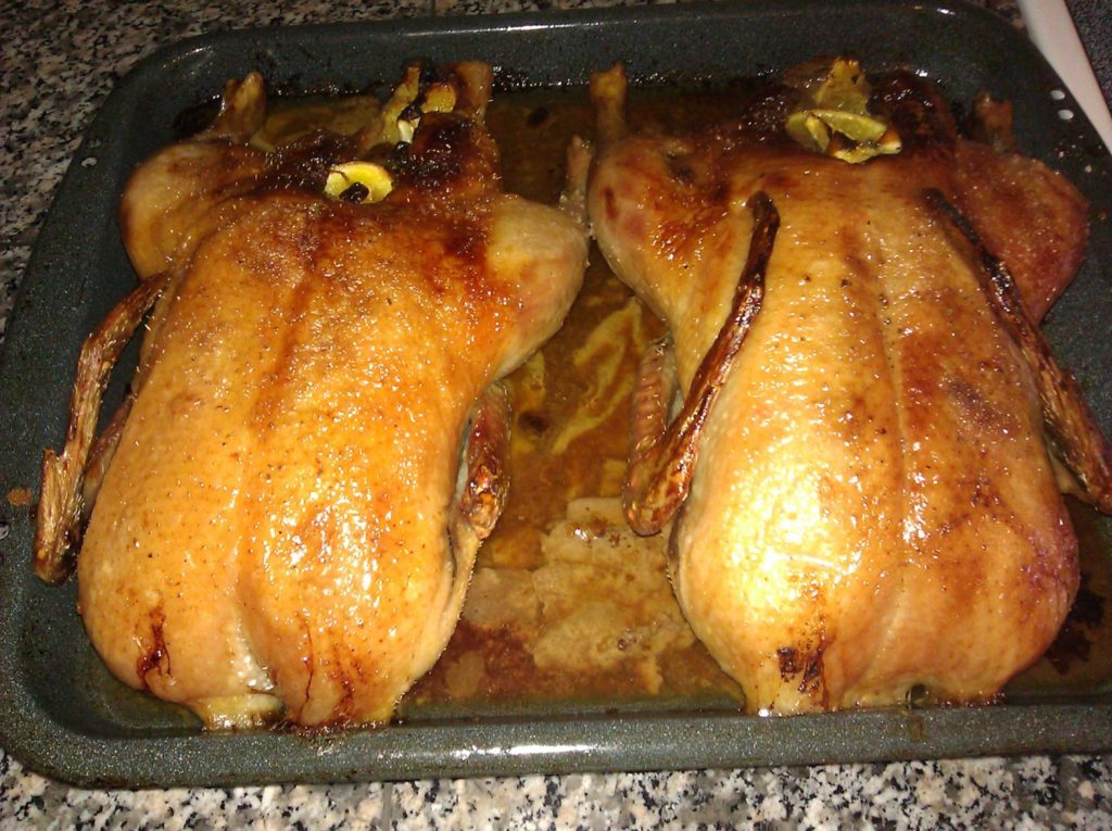 roasted ducks with broth in a pan