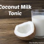 homemade and healthy coconut milk tonic beverage in a glass on wooden table