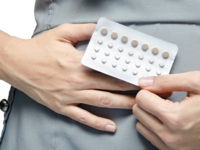 woman holding a blister pack of oral contraceptive pills