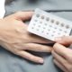 woman holding a blister pack of oral contraceptive pills