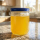 homemade stovetop ghee in glass jar on granite counter