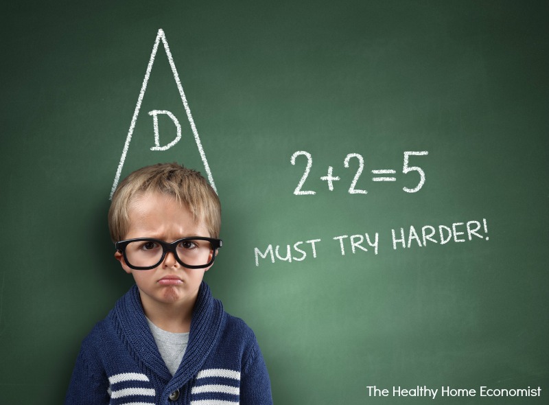 little boy trying to do a math problem on a chalkboard