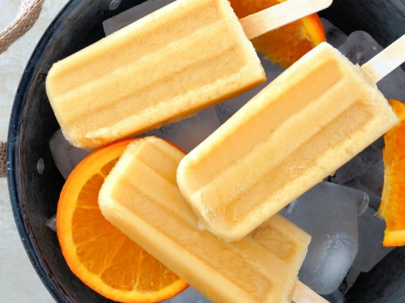 three homemade creamsicles with sliced orances on a platter