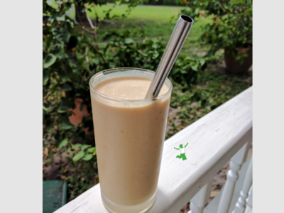 coconut milk smoothie in a glass with straw