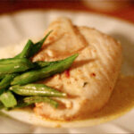 pan fried halibut with beans on white plate