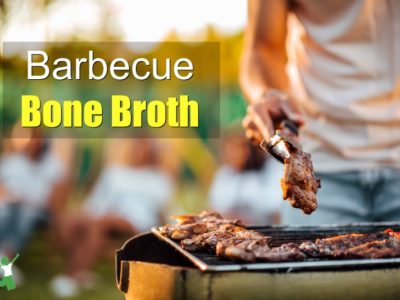 bone-in steaks and chicken on grill with man using tongs