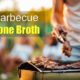 bone-in steaks and chicken on grill with man using tongs