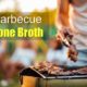 bone-in steaks and chicken on grill with man using tongs