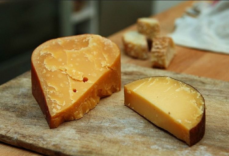 nutritious gouda cheese sliced on a cutting board