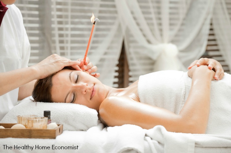 woman enjoying ear candling from a trained therapist