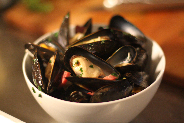 mussels and sausage in a white bowl