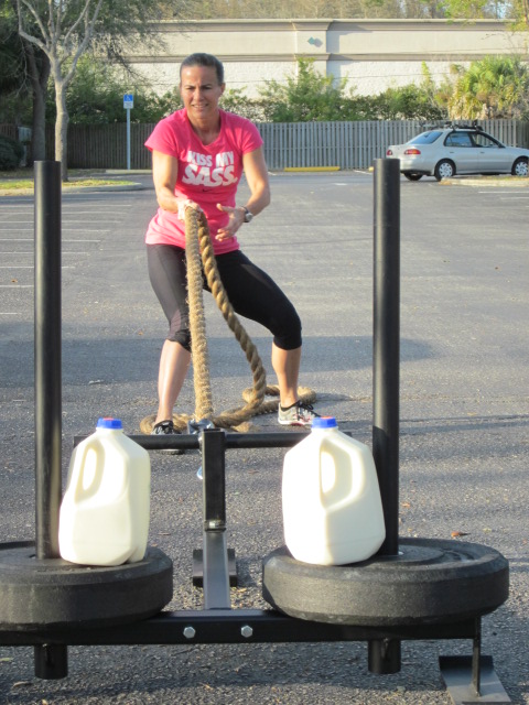 woman hauling heavy equipment with two gallons of raw milk