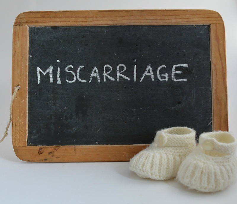 baby booties next to a chalkboard with the word miscarriage