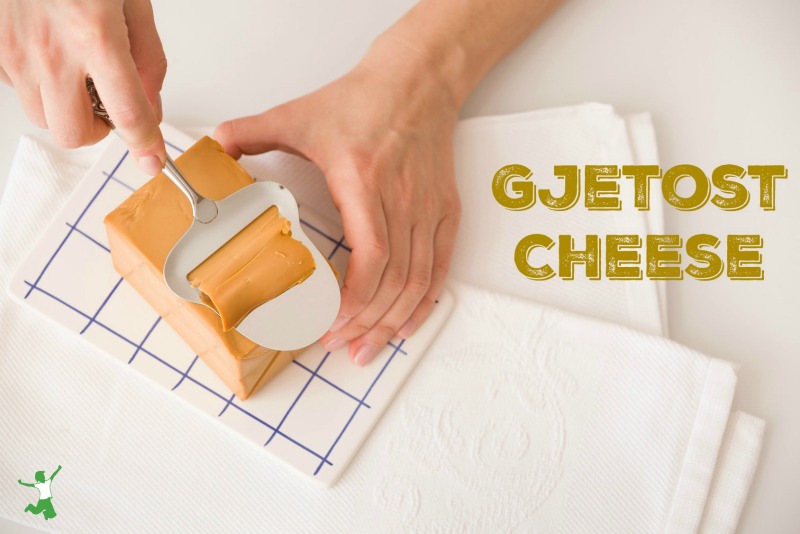 block of gjetost cheese being sliced on a cutting board