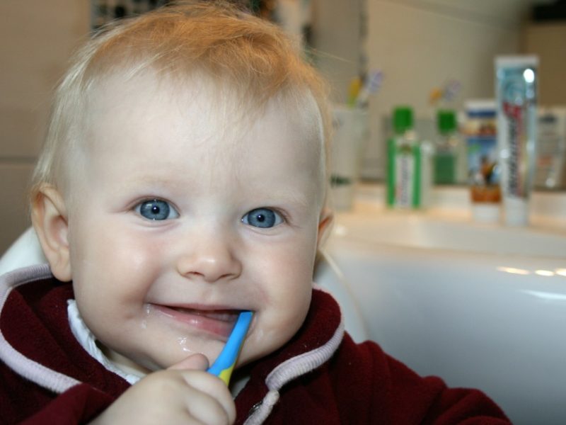 child with composite fillings brushing teeth
