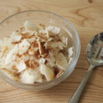 low carb coconut snack chips in glass bowl with spoon