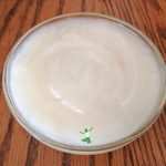 homemade sweetened condensed milk in glass bowl on wood table
