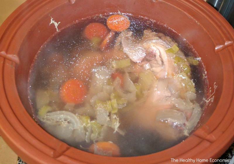 simmering lead-free bone broth in a clay pot