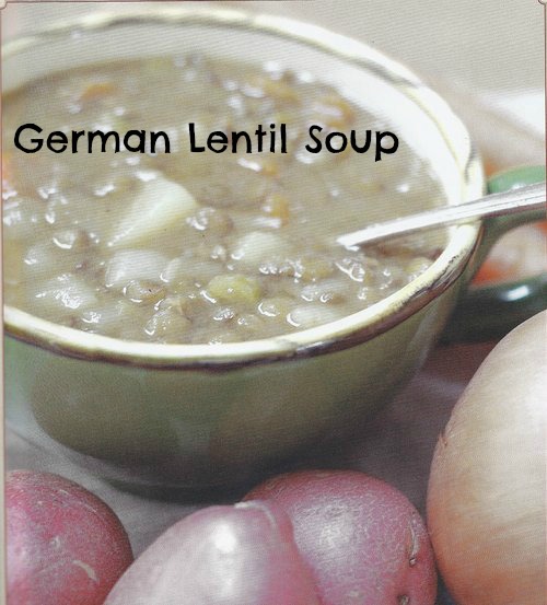 german lentil soup in a mug with potatoes on a table