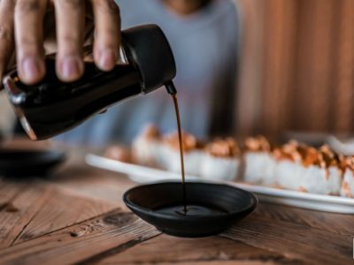 healthy soy sauce drizzling into a ceramic bowl
