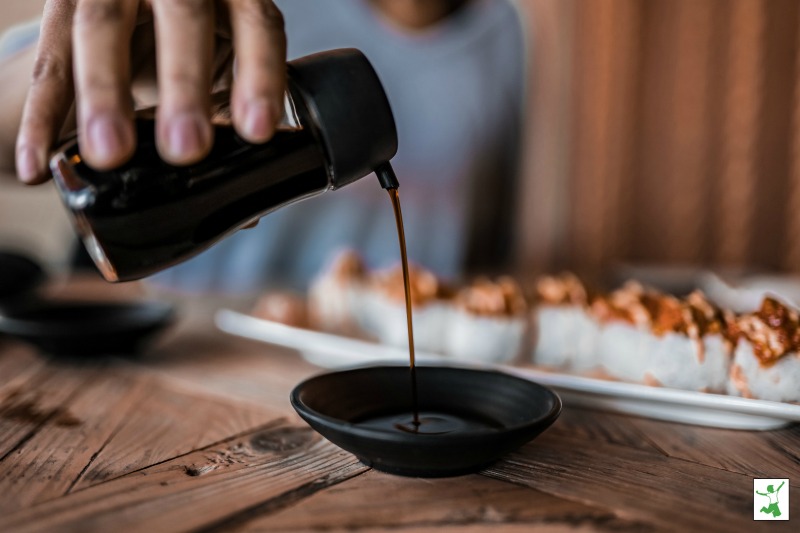 healthy soy sauce drizzling into a ceramic bowl