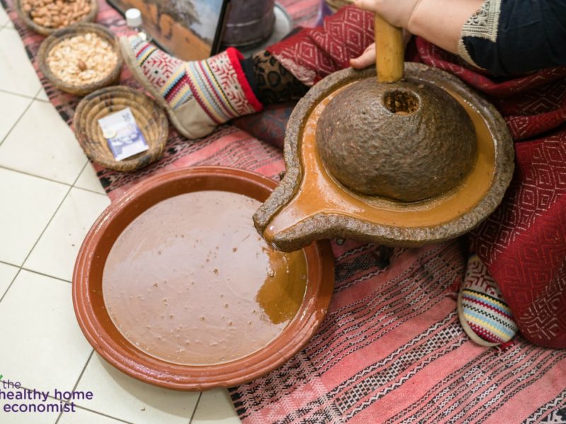 woman processing traditional argan oil by hand