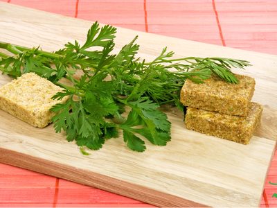 homemade bouillon cubes with lovage leaves on cutting board