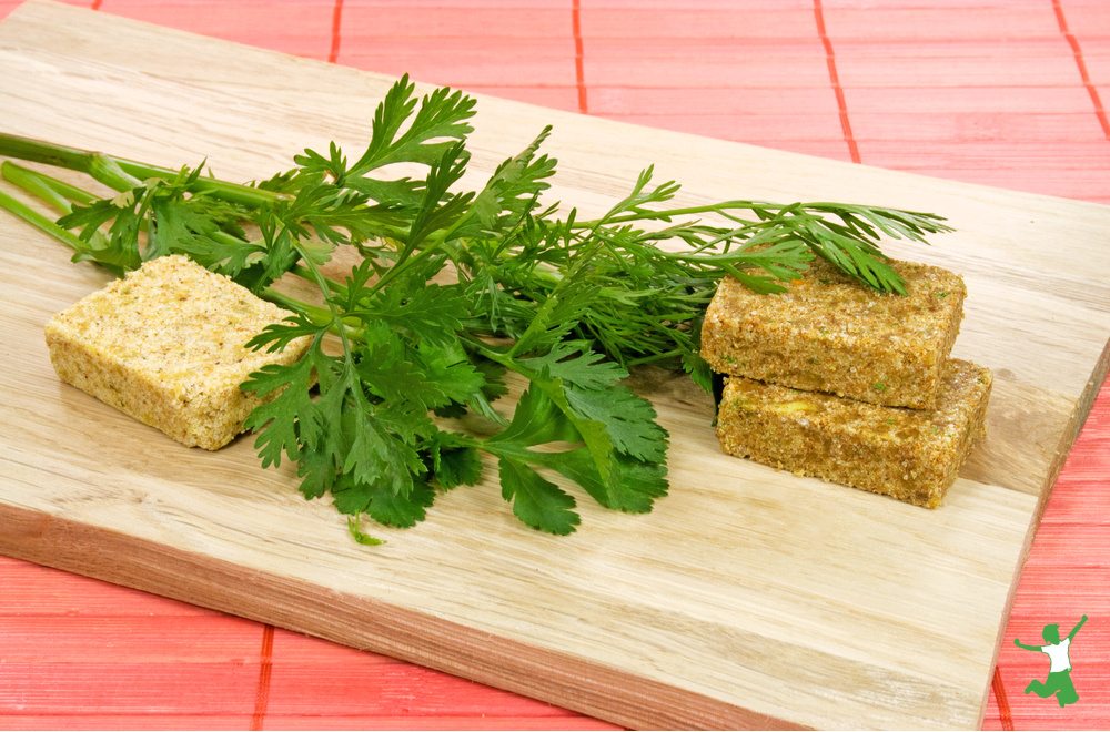 homemade bouillon cubes with lovage leaves on cutting board
