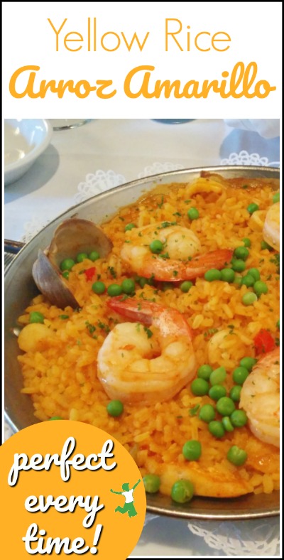 perfect yellow rice topped with peas and seafood in a stainless bowl
