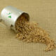 best farro spilling out of stainless steel cup onto a burlap mat