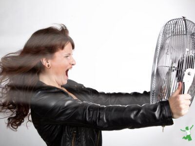 woman having a hot flash holding a fan