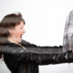 woman having a hot flash holding a fan