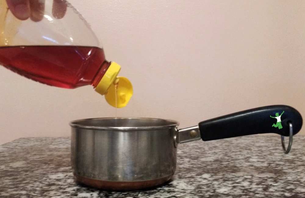 raw honey drizzled into a saucepan for cooking