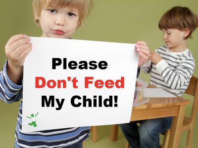 Child with FPIES holding a sign to not feed him