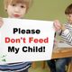 Child with FPIES holding a sign to not feed him