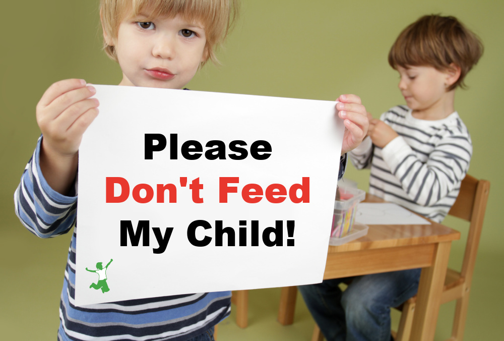 Child with FPIES holding a sign to not feed him