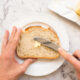 woman spreading butter on slice of sourdough bread