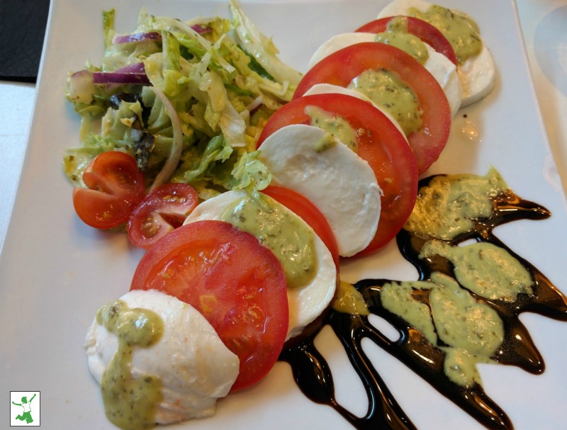 Caprese salad drizzled with balsamic on a white plate