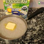 cooked buckwheat porridge in a pan with a pat of butter