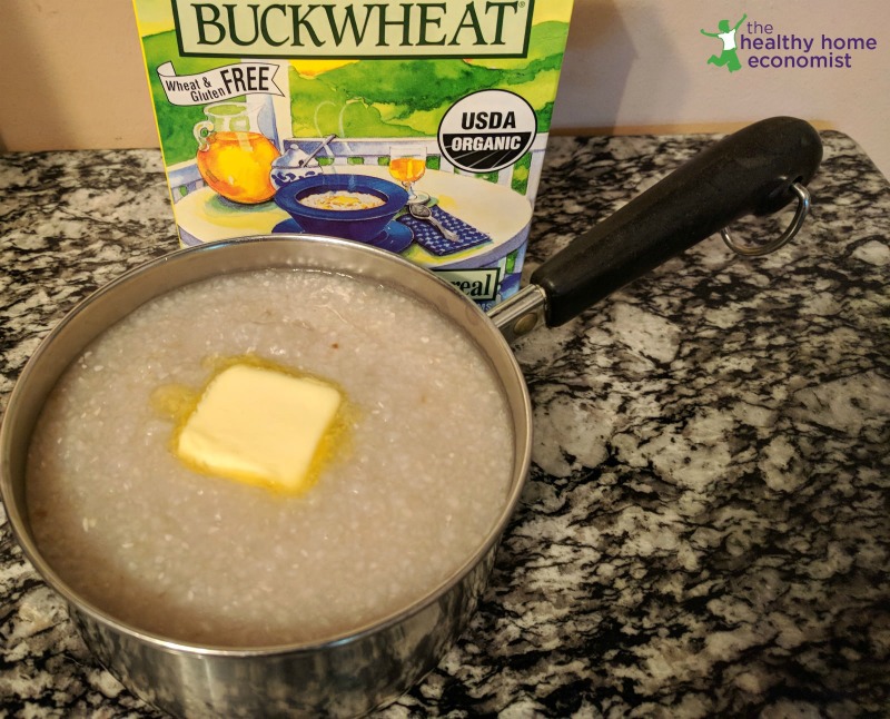 cooked buckwheat porridge in a pan with a pat of butter