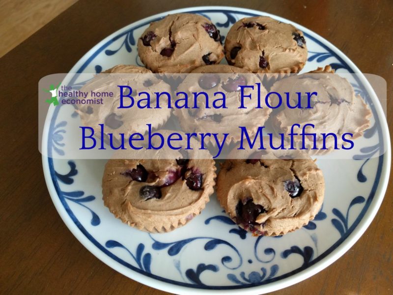 green banana flour blueberry muffins on a large plate on a wooden table