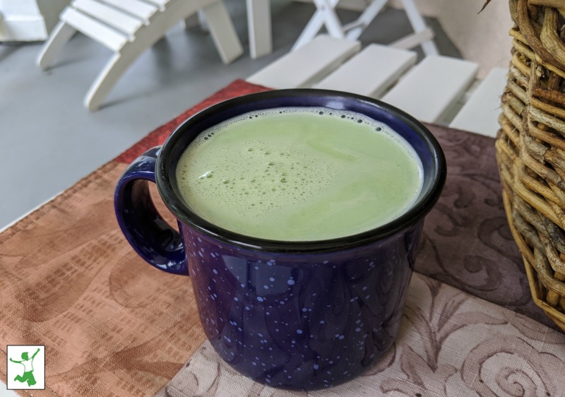creamy matcha latte with foam in a mug on a table
