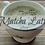 creamy matcha latte in a mug on a cutting board