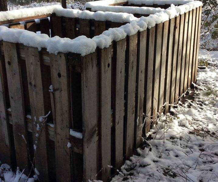 homemade compost bin rimmed with newly fallen snow