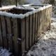 homemade compost bin rimmed with newly fallen snow